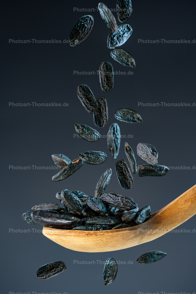 Schwarze Diamanten – die Magie der Tonkabohnen | Schwarze Diamanten – die Magie der Tonkabohnen. Kollektion: A spoon of tastefully seasonings.In dieser hochwertigen Foodaufnahme fallen echte, aromatische Tonkabohnen mit ihrem charakteristisch süßen und würzigen Duft auf einen rustikalen, alten Holzlöffel. Die Bewegung der fallenden Bohnen wurde mit Highspeed-Blitzen perfekt eingefroren, wodurch jedes Detail sichtbar bleibt. Der dunkle blaugraue Hintergrund mit sanftem Verlauf unterstreicht die natürliche Farbigkeit der Bohnen und die Textur des Holzes. Die Szene wirkt kraftvoll, authentisch und bietet einen faszinierenden Kontrast zwischen Bewegung und Ruhe – ideal für kulinarische Themen, Gewürzliebhaber und stilvolle Raumgestaltungen.Wo könnte man dieses Bild am besten aufhängen?Gourmet-Restaurant oder Pâtisserie – als kunstvolles Statement über feine Aromen und Handwerkskunst.Küche oder Esszimmer eines Feinschmeckers – zur stilvollen Inszenierung kulinarischer Leidenschaft.Delikatessengeschäft oder Gewürzladen – um die edle Vielfalt hochwertiger Gewürze visuell zu unterstreichen.Alu-Dibond: Die matte Oberfläche lässt die intensiven Farbtöne der Tonkabohnen besonders edel wirken und verleiht dem Bild eine moderne, elegante Wirkung – perfekt für gehobene Einrichtungen.Acrylglas: Die hochglänzende Oberfläche intensiviert die Farben und Details der Tonkabohnen sowie des Holzes und vermittelt Tiefe und Brillanz – ideal für moderne Küchen oder stilvolle Loungebereiche.Poster: Als großformatiges Poster bleibt die Lebendigkeit der fallenden Bohnen erhalten und bietet eine kostengünstige Möglichkeit, eine starke visuelle Wirkung zu erzielen – gut geeignet für kreative, wechselnde Dekorationen.Leinwand: Die textile Struktur harmoniert hervorragend mit der rustikalen Anmutung des Holzes und betont die Natürlichkeit und Wärme des Motivs – perfekt für gemütliche, stilvolle Wohnküchen oder Landhausambiente. - Realisiert mit Pictrs.com