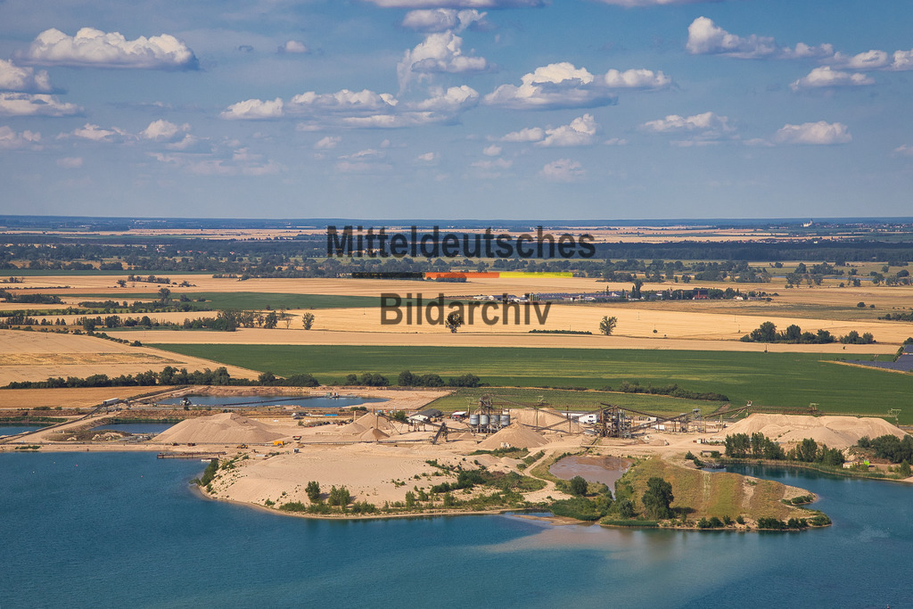 Kieswerk_Hülskens_Barby_1838 | Die Kieswerke der Hülskens Barleben GmbH &amp; Co. KG in Rothensee bei Magdeburg sowie in Tornitz und Barby gehören zu den bedeutenden Standorten der Kies- und Sandgewinnung in Sachsen-Anhalt. Die Luftaufnahmen aus der Perspektive des Tragschraubers zeigen die weitläufigen Abbauflächen mit ihren großen Kiesseen, modernen Förder- und Aufbereitungsanlagen sowie der leistungsfähigen Betriebstechnik. Aus der Vogelperspektive werden die Dimensionen der Rohstoffgewinnung und die enge Verbindung von Gewinnung, Aufbereitung und Rekultivierung eindrucksvoll sichtbar.
 - Realisiert mit Pictrs.com