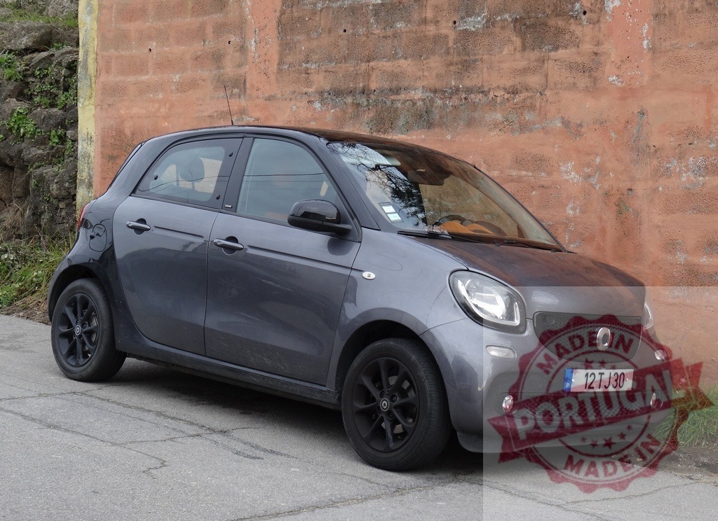 Smart Forfour compact car parked by brick wall | Grey Smart Forfour city car parked on a street next to an old brick wall - Realized with Pictrs.com