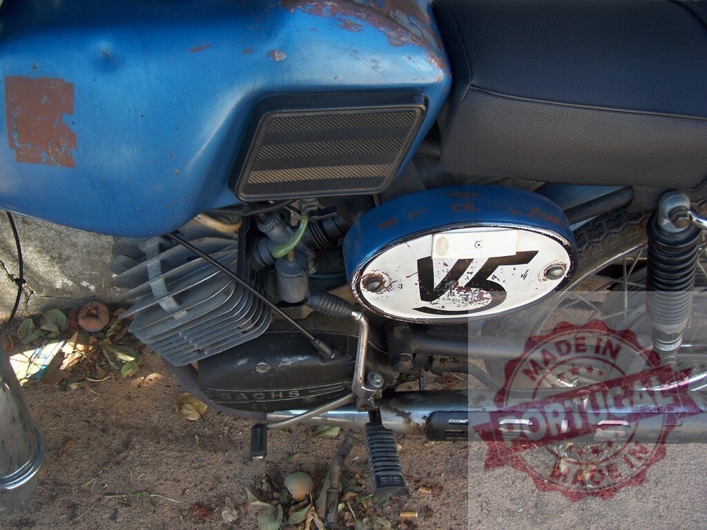 Rusty blue vintage Sachs motorcycle parked on dirt road | Close-up of a rusty blue vintage Sachs motorcycle parked on a dirt road, showing signs of age and wear - Realized with Pictrs.com