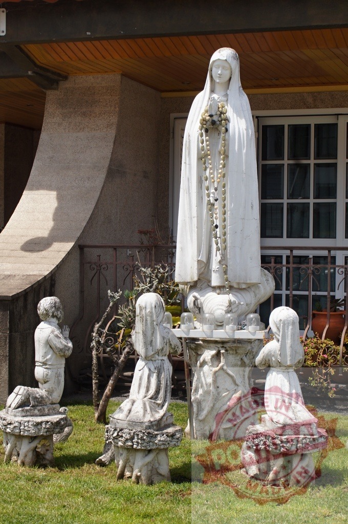 Our Lady of Fátima statue with praying children in garden shrine | Virgin Mary statue with a rosary surrounded by kneeling children praying - Realisiert mit Pictrs.com