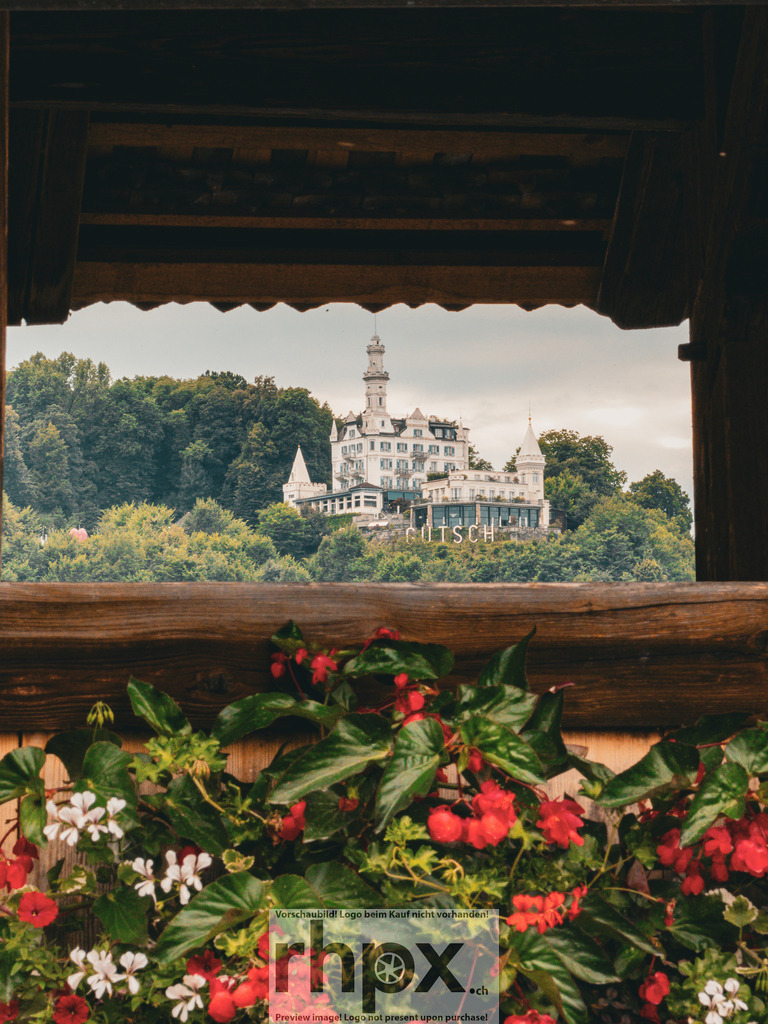 Schlossblick von der Kapellbrücke | Schloss. Rahmen. Idylle.Der Blick durch das historische Gebälk der Kapellbrücke offenbart das weisse Château Gütsch, das majestätisch über der Stadt thront. Die leuchtenden Geranien im Vordergrund verleihen dieser klassischen Luzerner Ansicht einen lebendigen Farbakzent.Wähle unter "Produktauswahl" dein Wunschformat: Vom klassischen Wandbild über Puzzle &amp; Tassen bis zum digitalen Download (z.B. als Handy-Hintergrund). - Realisiert mit Pictrs.com