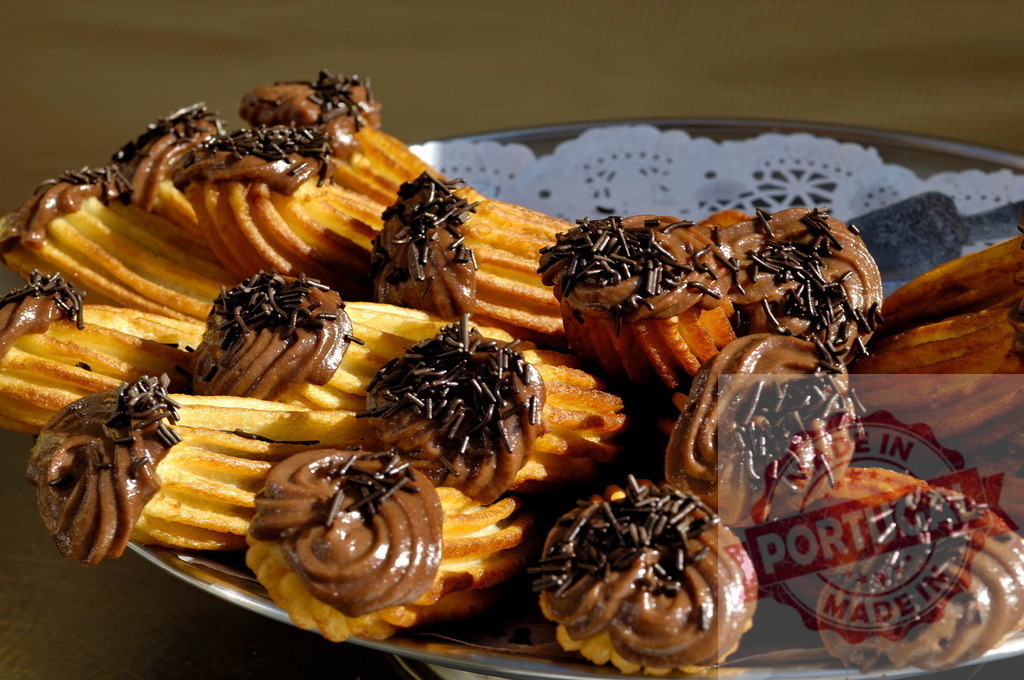 Churros con chocolate and sprinkles on platter | Delicious churros with chocolate cream and chocolate sprinkles on a serving platter - Realisiert mit Pictrs.com
