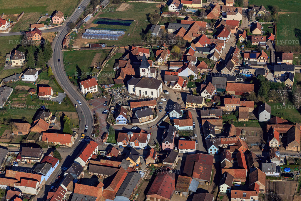 Aerial view: Church and cemetery in the village center in Lupstein in the state Bas-Rhin, France. – Photo: IMG_097564.jpg taken on 03/16/2017 by Werner Riehm/FLY-FOTO.com – Resolution of the original: 5472 x 3648 px
