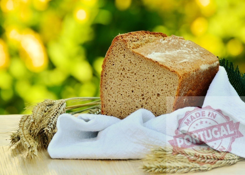 Fresh whole grain rye bread and wheat ears | Sliced loaf of healthy homemade bread with wheat ears on wooden table - Realisiert mit Pictrs.com