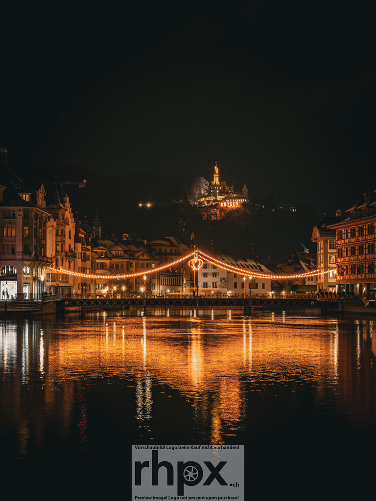 Weihnachtszauber & Château Gütsch | <p><strong>Lichter. Fluss. Wahrzeichen.</strong></p><p>Die festliche Beleuchtung über der Reuss taucht die Luzerner Altstadt in ein warmes, goldenes Licht. Über dieser stimmungsvollen Szenerie thront majestätisch das beleuchtete Château Gütsch im Hintergrund.</p><p>Wähle unter "Produktauswahl" dein Wunschformat: Vom klassischen Wandbild über Puzzle & Tassen bis zum digitalen Download (z.B. als Handy-Hintergrund).</p> - Realisiert mit Pictrs.com