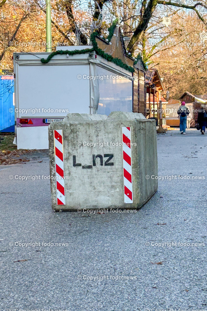 Linz_ Weihnachtsmarkt_ Terrorschutz_ 18.11.2025-16 | 18.11.2025, LINZ, AUT, Weihnachtsmarkt, im Bild Themenbild, Betonbarrieren, Betonblock, Terrorschutz, Volksgarten, Stadt, L_nz, Sicherheit, Fußgaengerzone, Weihnachtsmarkt, Huetten, Winter, Bauume ohne Laub, Absperrung, Verkehrsschutz, oeffentlicher Platz, Menschen, urban, Feature, Symbolbild
