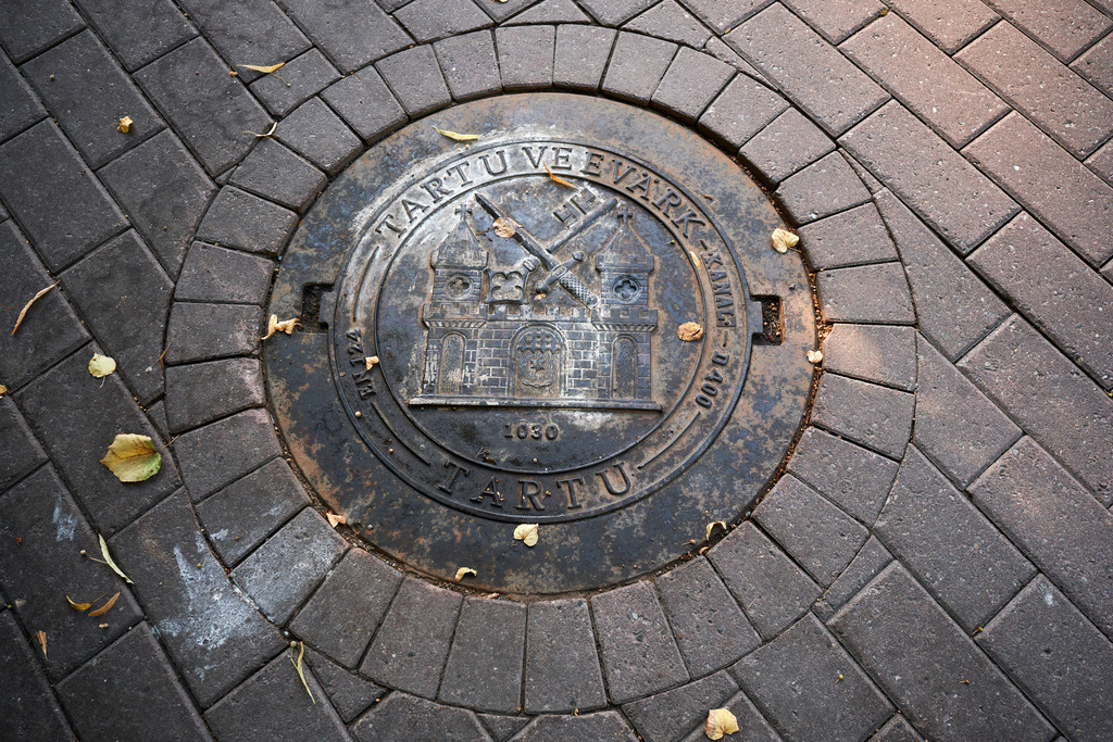Kanaldeckel mit Burg | Tartu, Estland - August 23, 2022: Kanaldeckel mit Burg in der Strasse. - Realisiert mit Pictrs.com