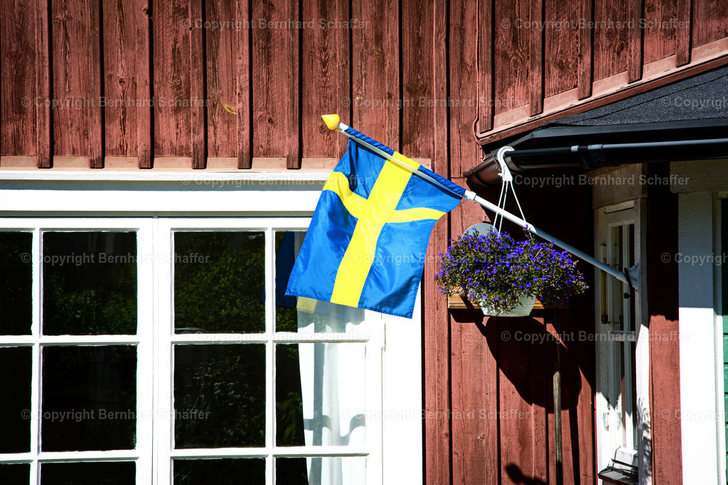 Schwedenhaus | Schwedische Flagge am Eingang eines typisch schwedischen Holzhauses. - Realisiert mit Pictrs.com