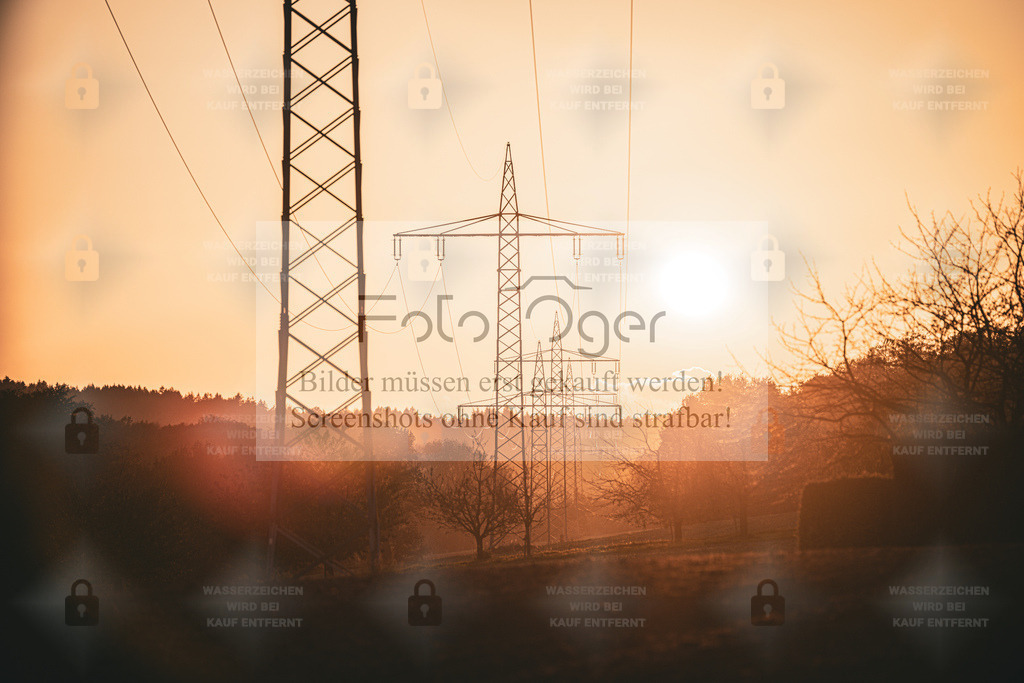 Energie im Abendlicht | Wenn die Sonne den Horizont berührt, verwandelt sich Technik in Silhouettenkunst.Die Strommasten zeichnen filigrane Linien in den goldenen Himmel – ein harmonisches Zusammenspiel zwischen Natur und moderner Infrastruktur. - Realisiert mit Pictrs.com