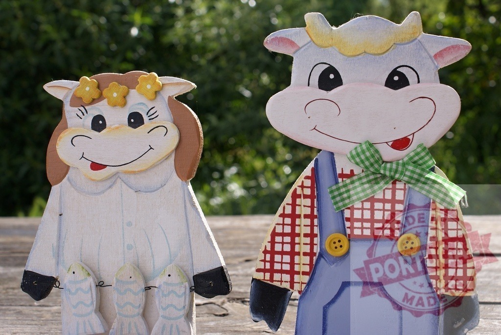 Cute wooden cow figurines displaying folk art style | Painted wooden cow and bull figurines standing together, symbolizing a happy couple - Realisiert mit Pictrs.com
