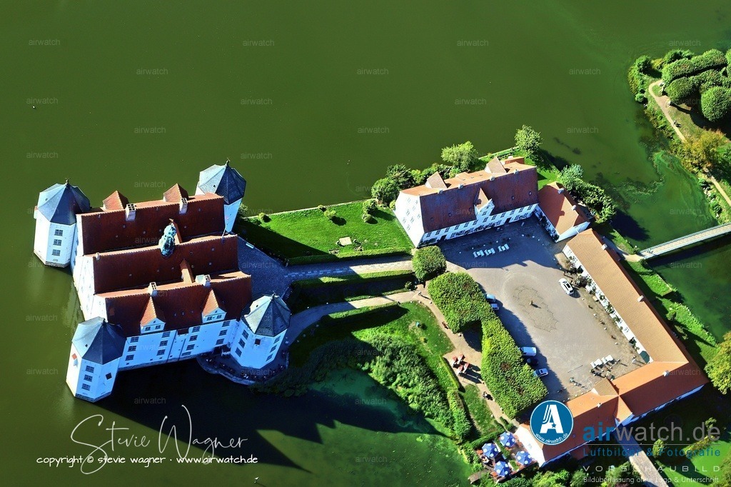 Luftbild Schloss Glücksburg -  Das Schloss wurde im Mai 1945 durch britische Truppen geplündert | Am Ende des Zweiten Weltkrieges diente das Schloss Glücksburg als Quartier für den NS-Reichsminister Albert Speer, der dort am 23. Mai 1945 von den Alliierten verhaftet und zunächst nach Flensburg gebracht wurde. Das Schloss wurde im Mai 1945 durch britische Truppen geplündert, wobei zahlreiche Wertgegenstände gestohlen wurden, von denen ein Teil später zurückgegeben wurde. Nach dem Ende der Regierung Dönitz wurde im Schloss zwischen dem 24. Mai und dem 1. August 1945 fast einhundertfünfzig ehemalige hohe Militärs als Gefangene untergebracht. Die Instandsetzung des Schlosses begann 1948, und es wurde im Pfingstfest 1948 mit einer Führung durch Friedrich Ferdinand Prinz zu Schleswig-Holstein mit hundert Teilnehmern eröffnet.