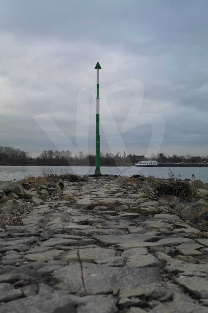 Rhine | At the end of a stony embankment in the Rhine, a navigation marker holds the course. Movement all around. - Realisiert mit Pictrs.com