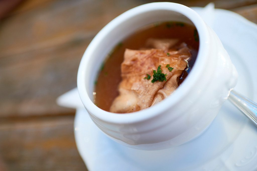 Suppe mit Fleischstrudel | Steiermark, Austria - August 27, 2017: Suppe mit Fleischstrudel in einer weissen Suppentasse auf einem Holztisch stehend. - Realisiert mit Pictrs.com