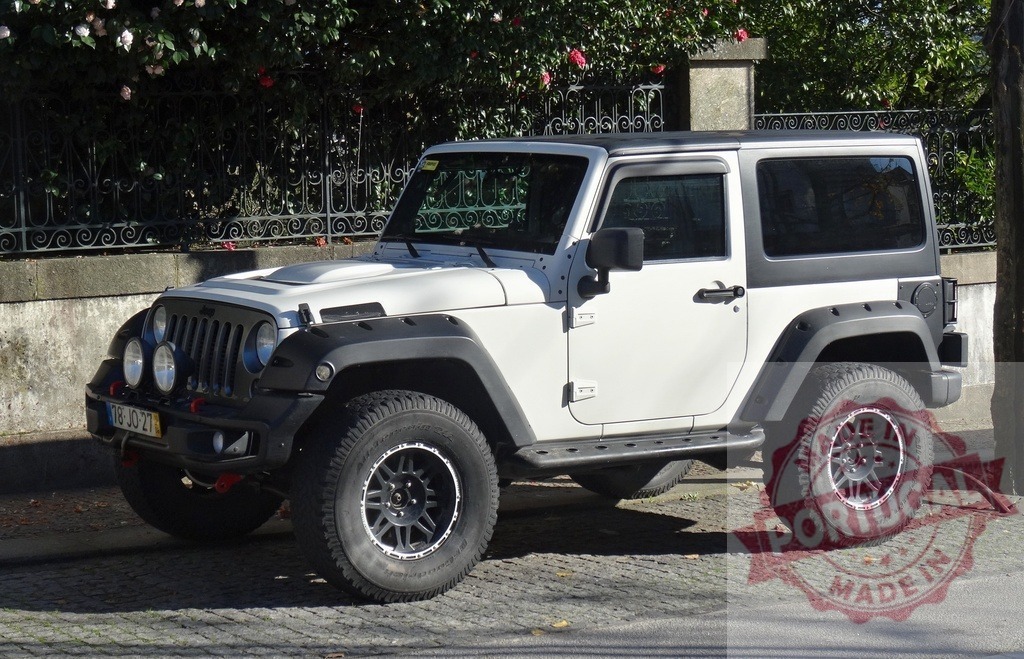 Modified white Jeep Wrangler parked on cobblestone street | White Jeep Wrangler customized for off-road driving parked outdoors on a sunny day - Realized with Pictrs.com