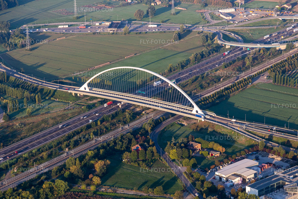 Aerial view: Ponte Di Calatrava bridge over the high-speed rail line and Autostrada del Sole in Reggio nell'Emilia in the state Reggio Emilia, Italy. – Photo: IMG_134805.jpg taken on 09/20/2022 by Werner Riehm/FLY-FOTO.com – Resolution of the original: 5472 x 3648 px – TURISMO.COMUNE.RE.IT