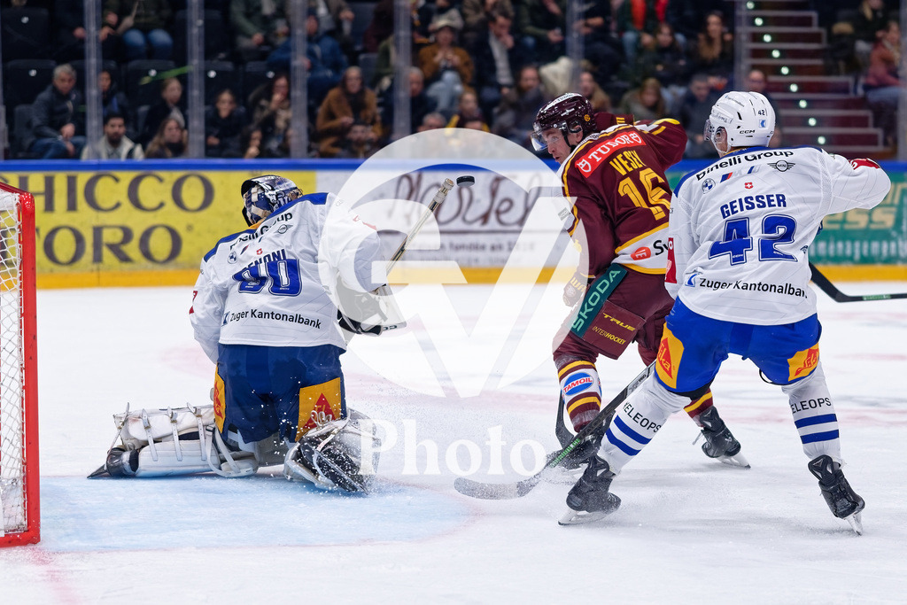 National League - Geneve-Servette HC v EV Zug | Jimmy Vesey (16 Geneve-Servette HC) in action (close up) battle for the puck (duel) Leonardo Genoni (30 EV Zug)  during the National League match between Geneve-Servette HC and EV Zug at Les Vernets in Geneva, Switzerland