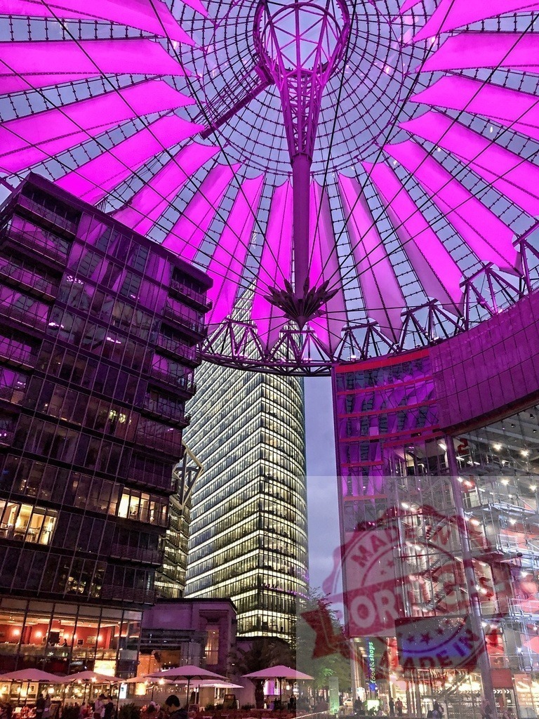Sony Center illuminated with purple lights at dusk in Berlin | Purple lights illuminating the inside of the Sony Center in Potsdamer Platz, Berlin - Realisiert mit Pictrs.com
