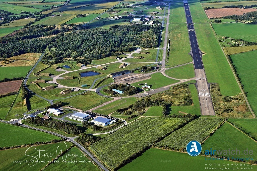Luftbild Flughafen Husum-Schwesing - Der Fliegerhorst Husum wurde nach Gründung der Bundeswehr am 16. Oktober 1959 offiziell in Betrieb genommen | Der Fliegerhorst Husum wurde nach Gründung der Bundeswehr am 16. Oktober 1959 offiziell in Betrieb genommen und wurde Standort des „ersten“, „norddeutschen“ Jagdbombergeschwaders 35 (JaBoG 35), das später in Leichtes Kampfgeschwader 41 und schließlich als Jagdbombergeschwader 41 fortgeführt wurde. Die dem Fliegerhorst zugeordnete Kaserne ist die Fliegerhorstkaserne Husum.