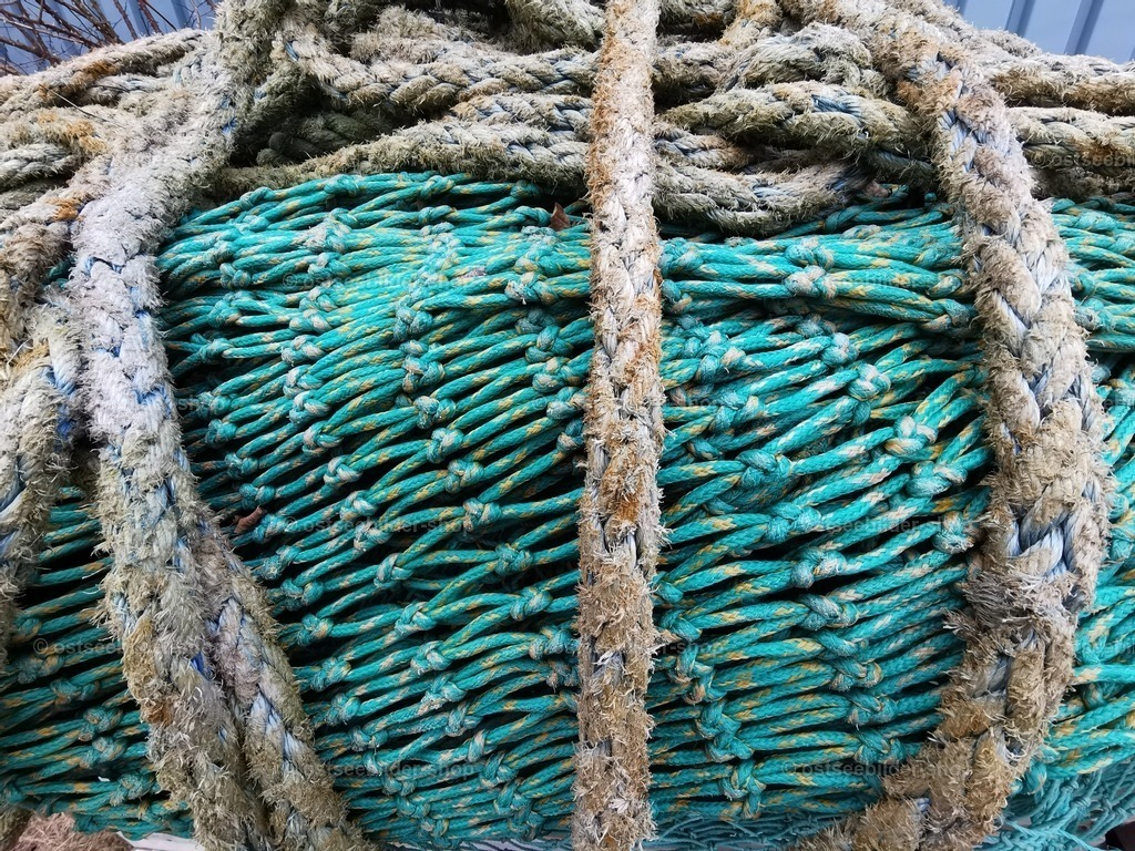 Tauwerk und Fischernetz im Detail | Ein aufgerolltes Netz wird von kräftigem Tauwerk zusammengehalten.