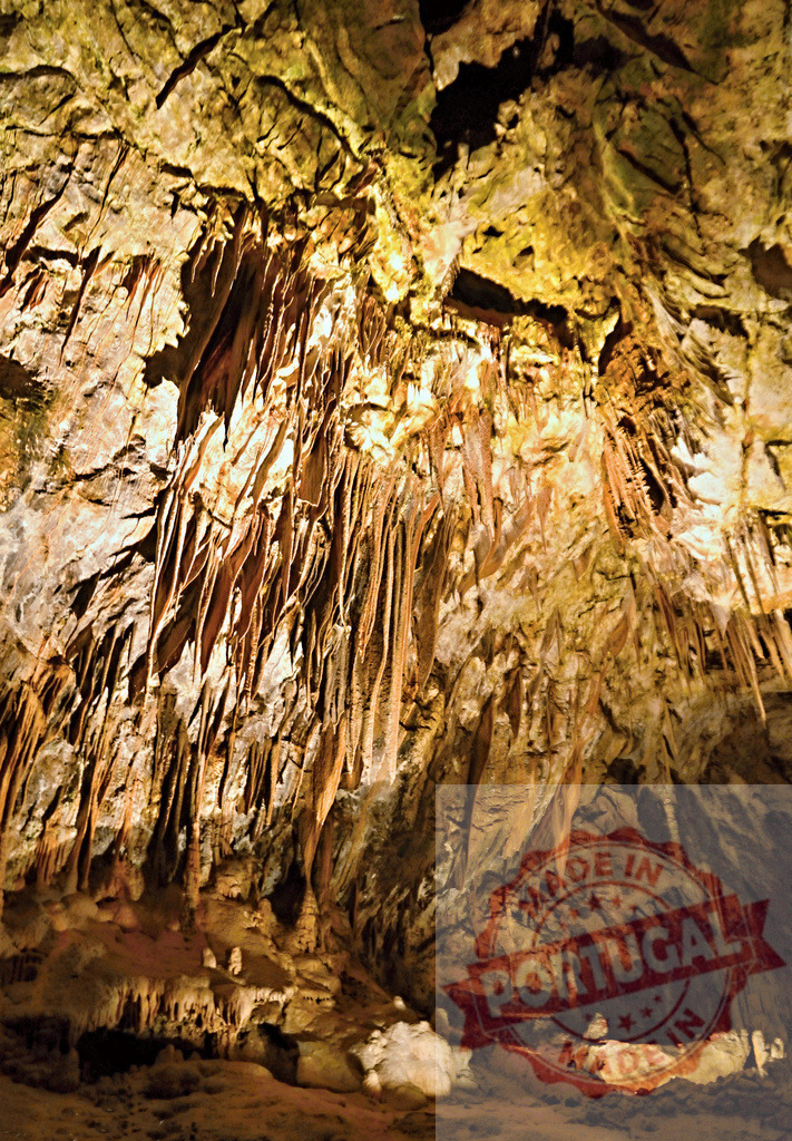 Stalactites hanging from cave ceiling creating mesmerizing patterns | Illuminated stalactites hanging from the ceiling of a cave, creating mesmerizing patterns in warm colors - Realisiert mit Pictrs.com