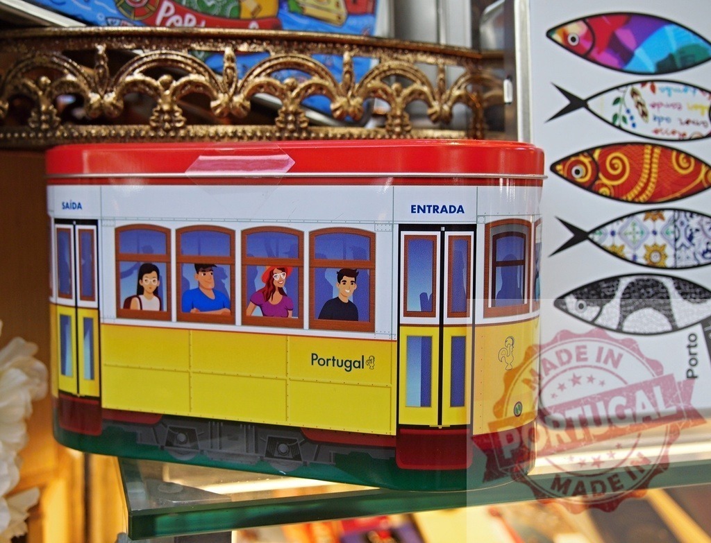 Lisbon tram tin souvenir representing Portuguese culture | Portugal tram souvenir tin showing animated people in windows and sardine magnet - Realisiert mit Pictrs.com