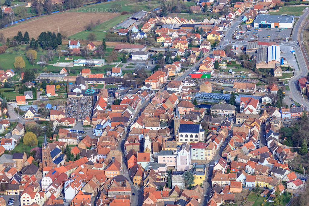 Aerial view: Rue du Dr. Albert Schweitzer with Eglise Saints Pierre et Paul de Pfaffenhoffen and Église protestante de Pfaffenhoffen-Niedermodern in Val-de-Moder in the state Bas-Rhin, France. – Photo: IMG_38635.jpg taken on 03/20/2011 by Werner Riehm/FLY-FOTO.com – Resolution of the original: 4752 x 3168 px
