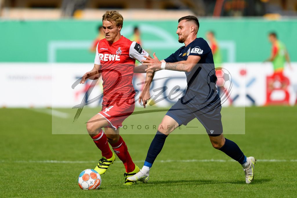 JENKOE20210808_045 | Fussball, Herren: Timo Huebers (1. FC Koeln) und Maximilian Wolfram (FC Carl Zeiss Jena) im Zweikampf beim Spiel der 1. Runde im DFB-Pokal zwischen FC Carl Zeiss Jena und 1. FC Koeln im Ernst-Abbe-Sportfeld am 08.08.2021 in Jena, Deutschland.DFB / DFL REGULATIONS PROHIBIT ANY USE OF PHOTOGRAPHS AS IMAGE SEQUENCES AND/OR QUASI-VIDEO. - Realisiert mit Pictrs.com