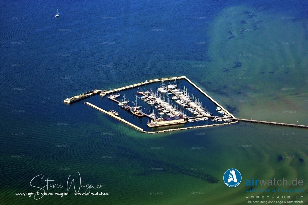 Luftbild Wackerballig Yachthafen - Koordinaten: 54°45'27"N   9°52'25"E | Koordinaten: 54°45'27"N   9°52'25"E • ca. 200m lange Zugangsbrücke • 230 Liegeplätze für Boote bis 17 m Länge • 2,50 - 3,00 m Wassertiefe im Hafen • Frischwasser ist an den Stegen alle 25m • Stromanschlüsse (230 V) alle 30m • Entsorgung von Abfällen • kostenlose Parkmöglichkeiten