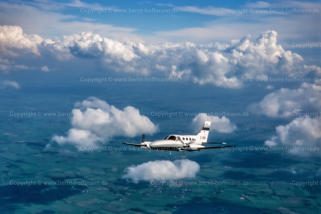 PLBDD_air2air_C421_07_90x60 | Luftbild. Zweimotoriges Geschäftsflugzeug ( Typ CESSNA 421 ) über den Wolken und zwischen Cumulus- Wolken im Luftraum zwischen Flensburg und Nordfriesland. ___ Das Foto ist eine Reproduktion von einem Farbdia. - Realisiert mit Pictrs.com
