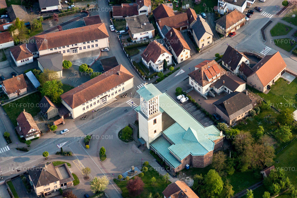 Aerial view: Church building with blue roof in the village center in Offendorf in the state Bas-Rhin, France. – Photo: IMG_39546.jpg taken on 04/14/2011 by Werner Riehm/FLY-FOTO.com – Resolution of the original: 4752 x 3168 px