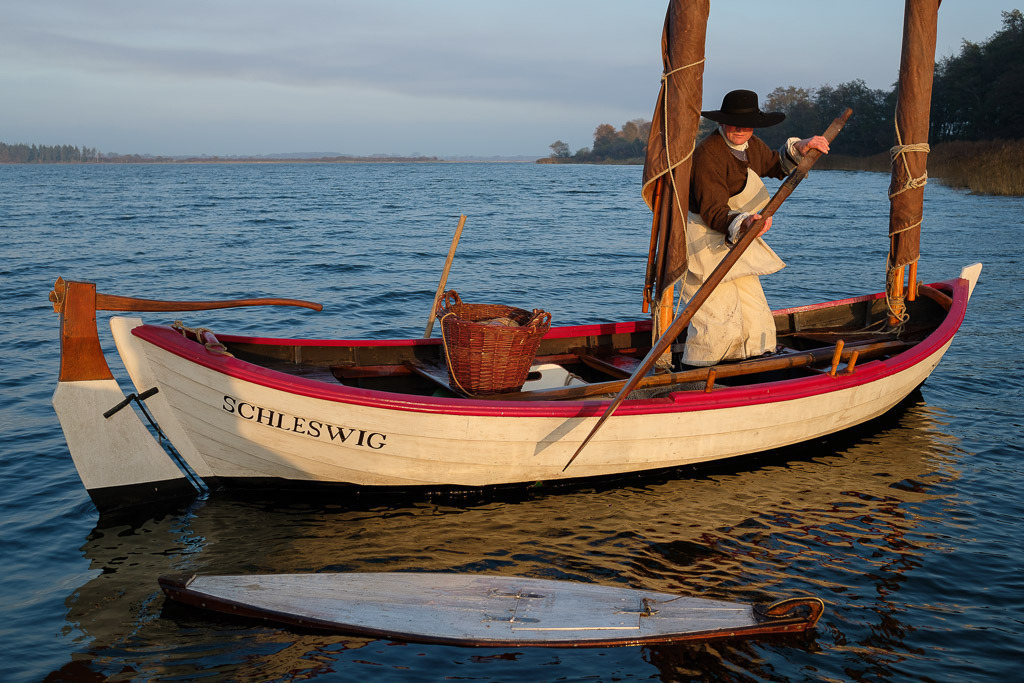zeitenwende-farbe-03-23 | Der Schleifischer Jörg Nadler vom Holm in Schleswig in historischer Bekleidung auf der Kleinen Breite der Schlei. - Realisiert mit Pictrs.com
