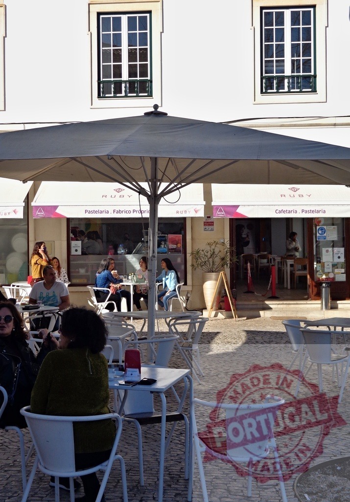 People enjoying a cafe terrace on a sunny day | Patrons relaxing and socializing at an outdoor cafe in a European city - Realisiert mit Pictrs.com