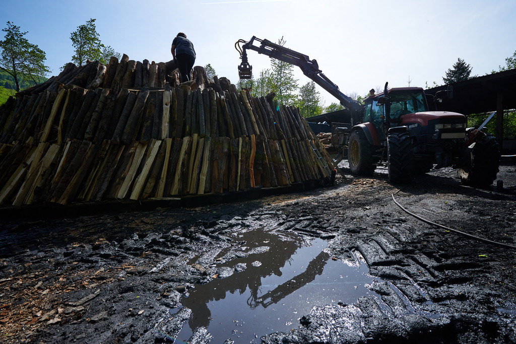Aufschichten des Meilers mit dem Holzkran | Michelbach, Austria - May 08, 2019: Waldköhlerei Hochecker, die 2011 in das Nationale Verzeichnis des immateriellen Kulturerbes der UNESCO aufgenommen wurde, produziert noch echte Holzkohle; Aufschichten des Meilers mit dem Holzkran. - Realisiert mit Pictrs.com