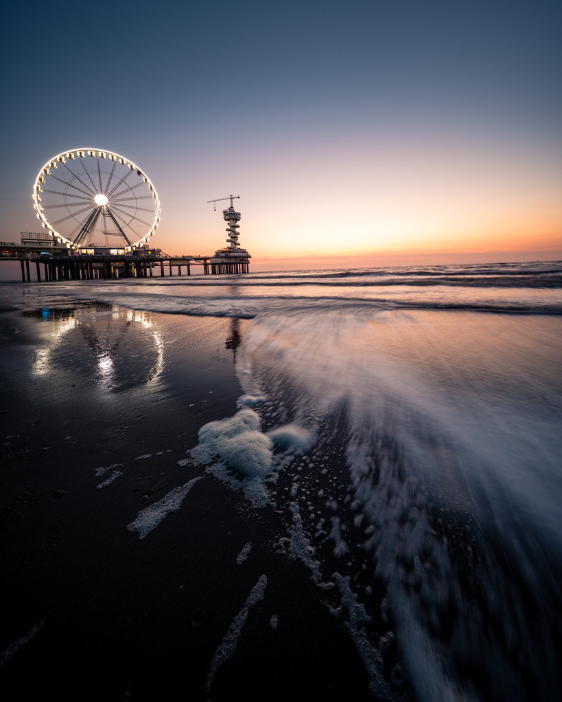 Spiegelung des Riesenrads am Strand von Scheveningen | Minimalistische Abendaufnahme des Riesenrads von Scheveningen mit einer klaren Spiegelung im ruhigen Wasser auf dem Strand. - Realisiert mit Pictrs.com