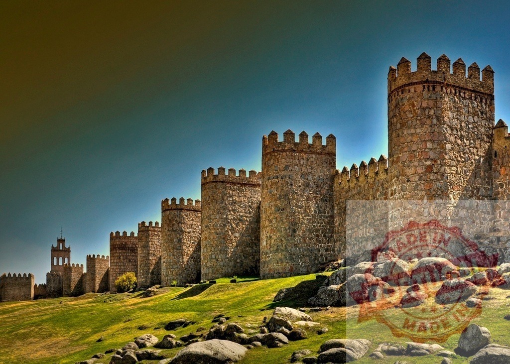 Walls of Avila, Spain, standing as medieval fortification. Spain - Avila | Walls of Avila presenting ancient stone towers on a green hillside under a clear sky - Realized with Pictrs.com