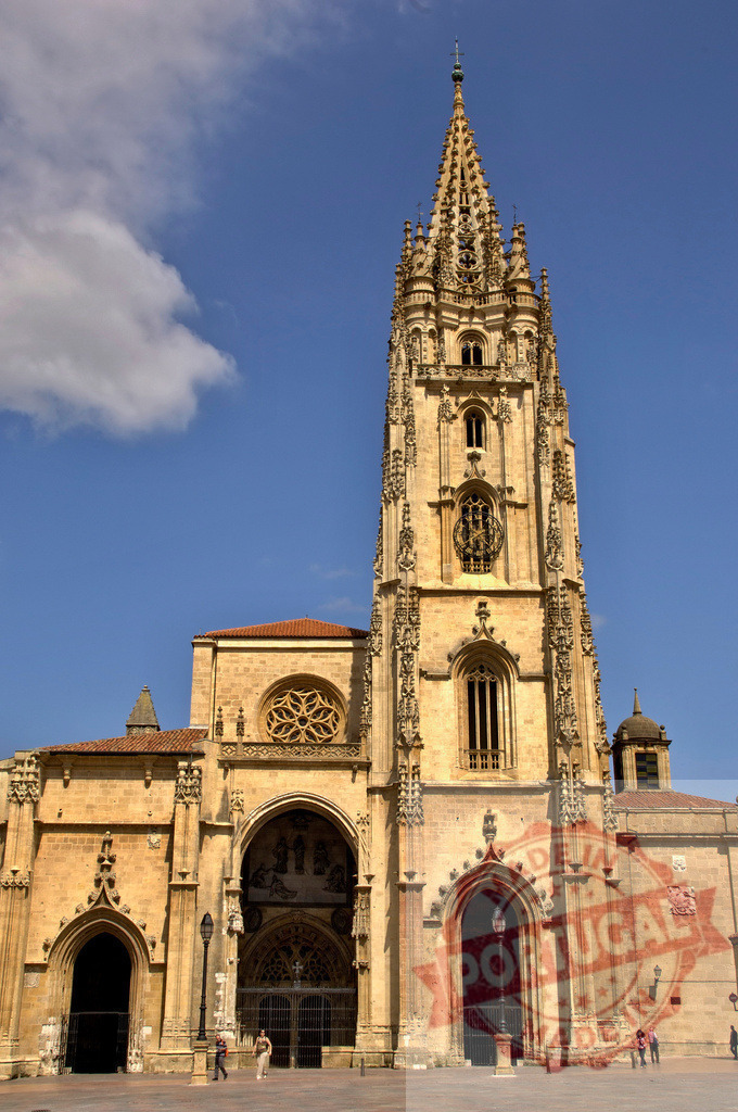 Oviedo Cathedral tower and facade showing Gothic architecture in Spain | Oviedo Cathedral exterior with its iconic Gothic spire against a blue sky, attracting tourists in Asturias - Realized with Pictrs.com