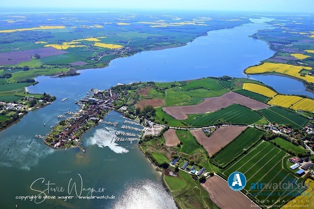 Luftbild Ostseefjord Schlei, Stadt Arnis - kleinste Stadt Deutschlands - Perle an der Schlei | Am 1. Januar 1934 wurde Arnis zunächst de jure Stadt, und der 14. April 1934 gilt als das eigentliche Stadtgründungsdatum, an dem der Schleswiger Landrat Anton Wallroth den ehrenamtlichen Bürgermeister ernannte. Diese Entscheidung war Teil einer politischen Gleichschaltung, bei der alle bisherigen Flecken und Städte in Schleswig-Holstein zur Stadt erklärt wurden. 