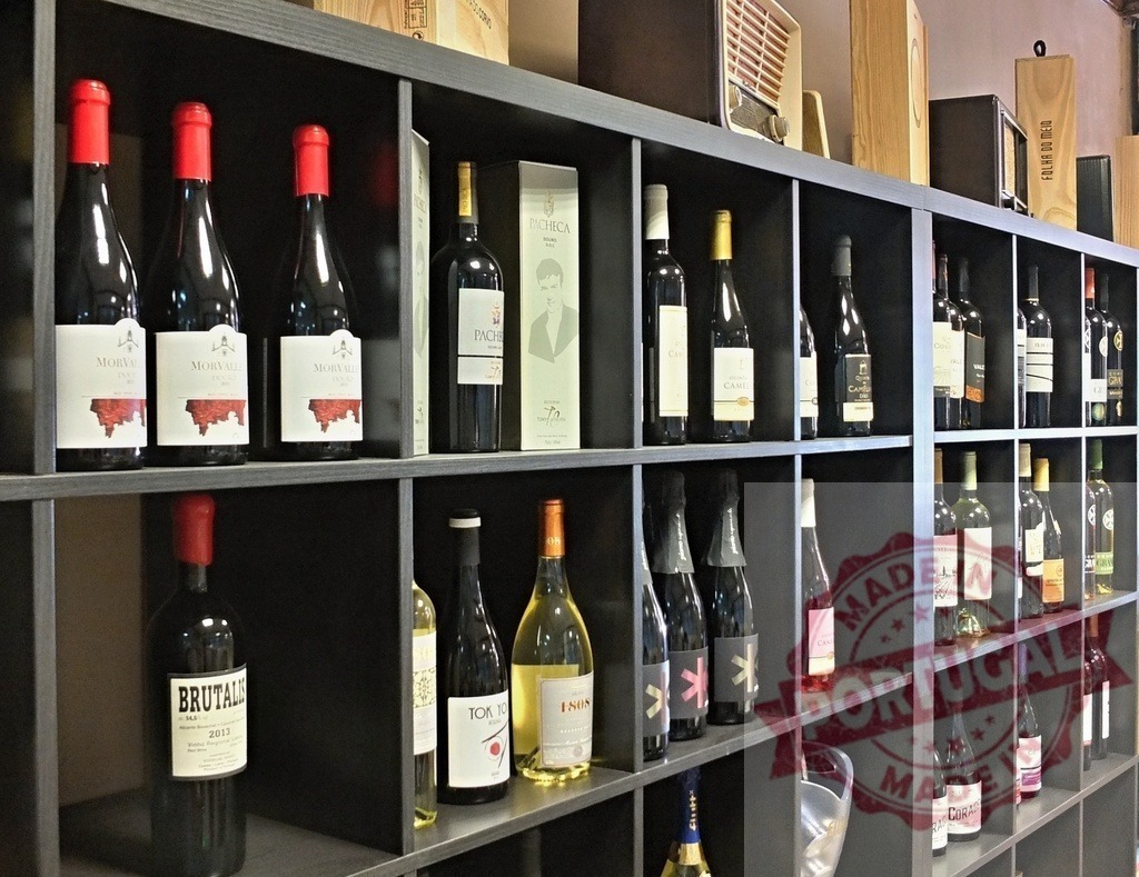 Wine bottles filling black retail store shelves | Wine bottles displayed on black shelves in a store, offering variety to customers - Realized with Pictrs.com