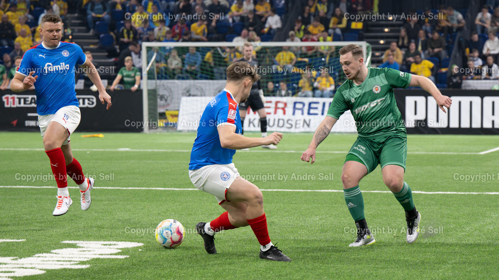 SHFV Lotto Masters 2024 | 20240113_7188, 13.01.2024, SHFV Lotto Masters 2024, Gruppe B, Holstein Kiel (blau) vs. PSV Neumünster (grün), Laurynas Kulikas (Holstein #19) &amp; Jan Wansiedler (Holstein #2) / Marc-Oliver Timm (PSV #5) - Realisiert mit Pictrs.com