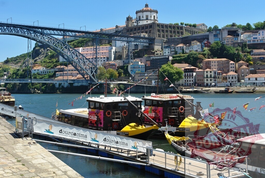 Porto cityscape with Dom Luís I Bridge and rabelo boats. Porto - Portugal | Rabelo boats moored on the Douro River with the bridge and city in the background - Realisiert mit Pictrs.com