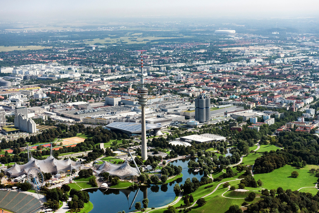 dr__0071260.jpg | MüNCHEN 12.08.2021 Der Olympiapark in München im Bundesland Bayern. Im Vordergrund liegt das Olympiastadion, das heute für Veranstaltungen und Konzerte genutzt wird. Dahinter liegt der Fernsehturm, der Olympiaturm, eines der Wahrzeichen Münchens. Ebenfalls sichtbar ist die Parkanlage sowie der große See. Gemeinsam bilden sie eine der größten Grünflächen der Stadt. // The Olympic Park in Munich in the state of Bavaria. In the foreground lies the Olympic Stadium that is today used for cultural events and concerts. Behind it, the TV tower, the Olympic Tower, one of the landmarks of the city is visible. The large park and lake form one of the largest open spaces in Munich. Foto: Daniel Reiter