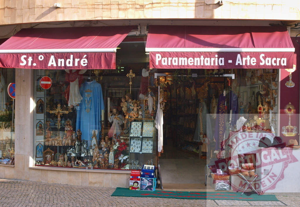 Religious shop selling christian liturgical objects in Fatima, Portugal | Shop window displaying religious objects including vestments, statues, crosses, and rosaries in Fatima, Portugal - Realisiert mit Pictrs.com