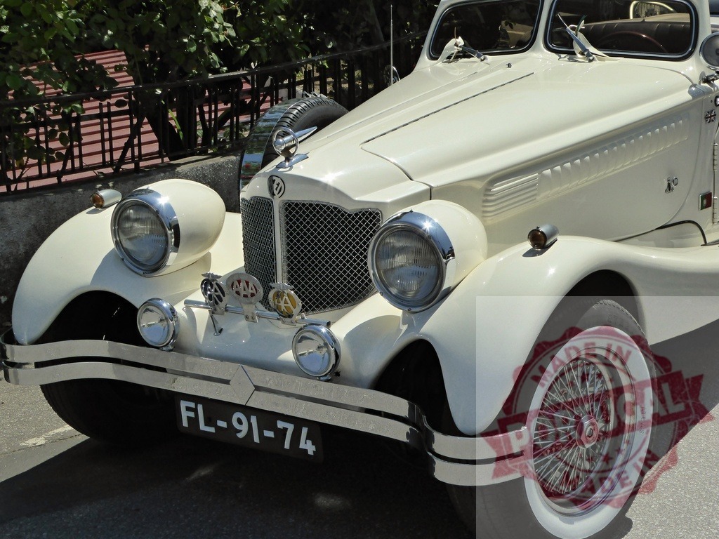 Vintage white roadster showing classic luxury design | White vintage car displaying chrome details, whitewall tires, and an elegant frontal grille - Realisiert mit Pictrs.com
