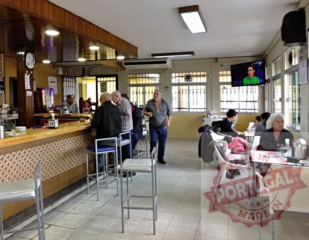 People socializing and relaxing inside a traditional bar | People enjoying drinks and conversation in a casual bar interior with tables and a television - Realisiert mit Pictrs.com