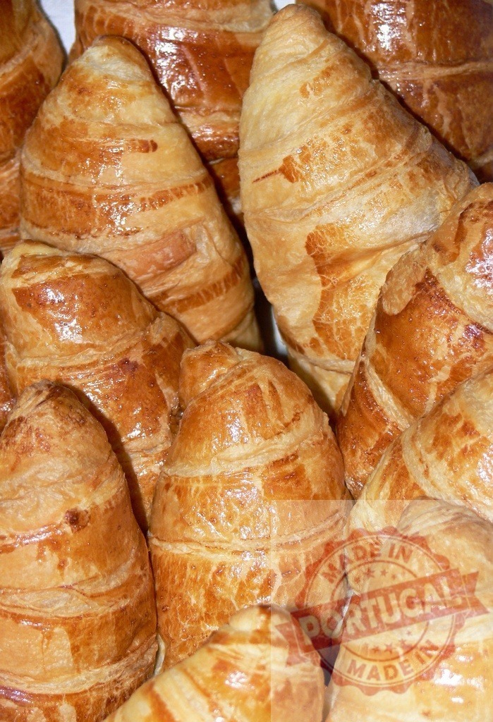 Freshly baked golden croissants filling frame | Delicious croissants showing flaky layers and a golden brown finish - Realisiert mit Pictrs.com