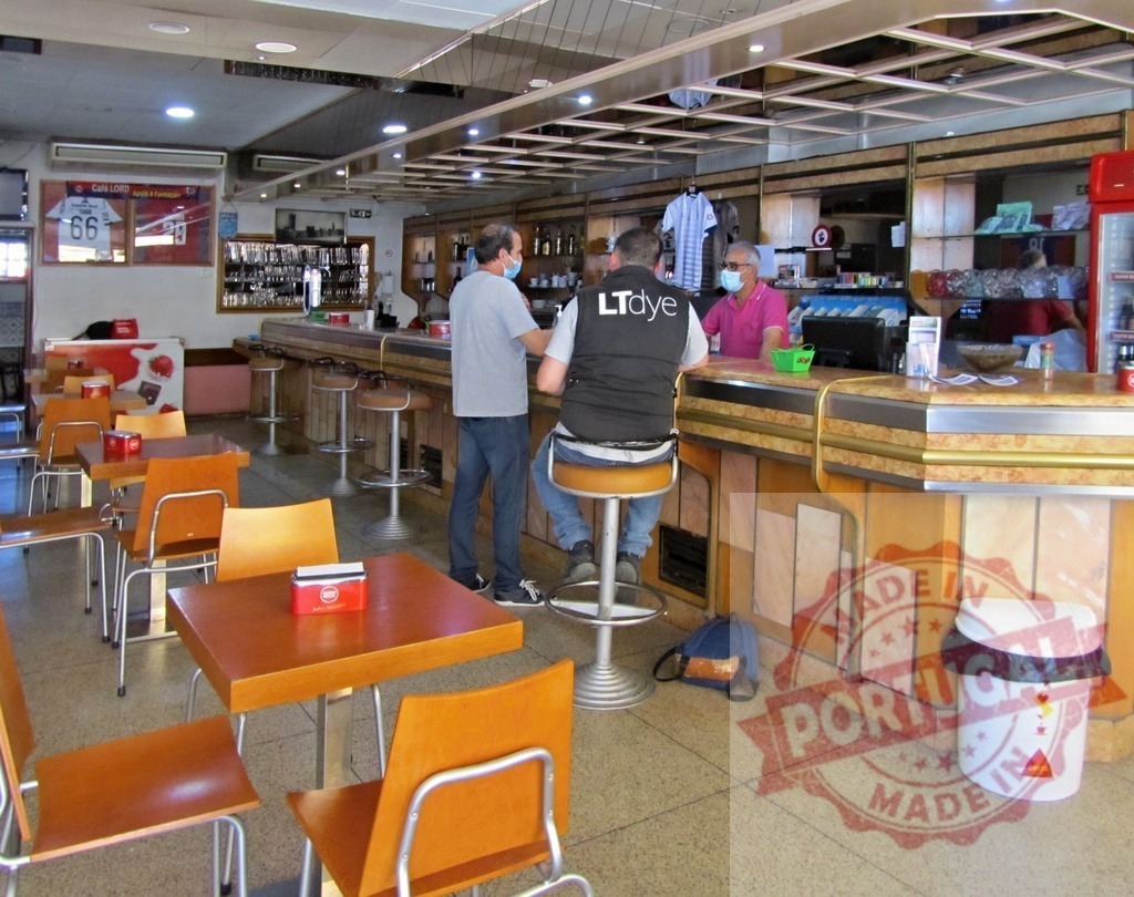 People wearing face masks inside bar during pandemic | Customers and staff wearing surgical masks at a bar counter while following safety protocols - Realized with Pictrs.com