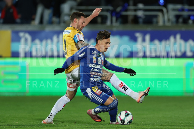 TSV Egger Glas Hartberg vs SV Oberbank Ried – Austrian Bundesliga Match | The image shows Jonathan Scherzer (Ried) and Lukas Fridrikas (Hartberg) fight for the ball, at the Bundesliga match TSV Hartberg vs SV Ried at Profertil Arena Hartberg. 22.11.2025