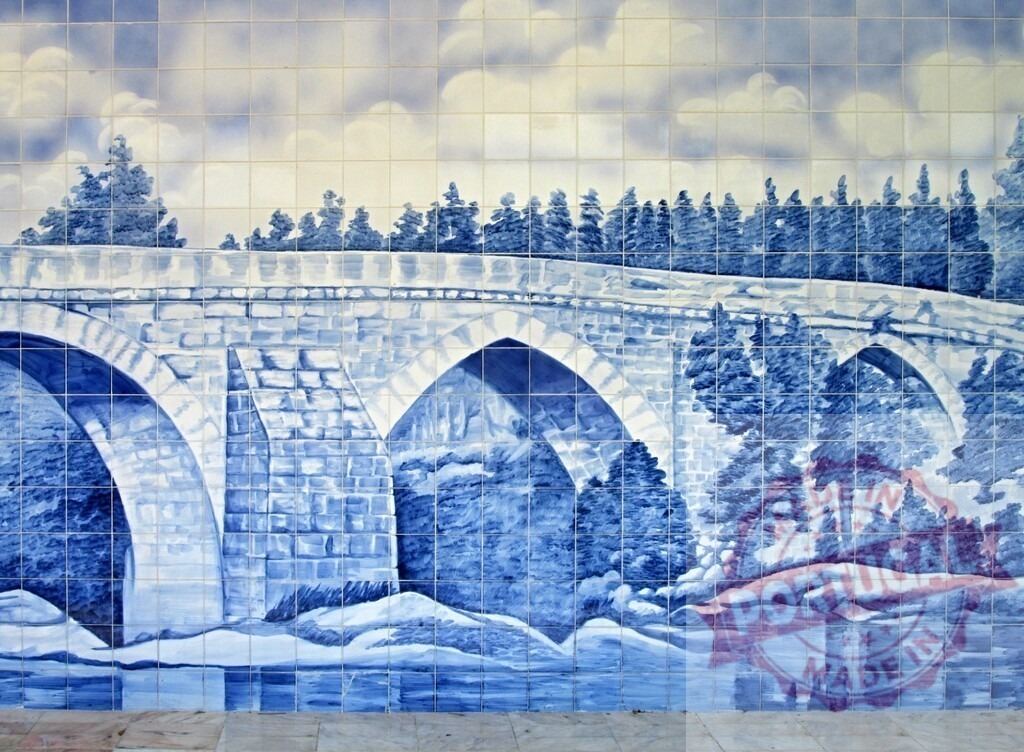 Azulejo tile mural portraying stone bridge over water | Blue and white painted azulejo tile mural depicting a neoclassical stone bridge and landscape - Realized with Pictrs.com