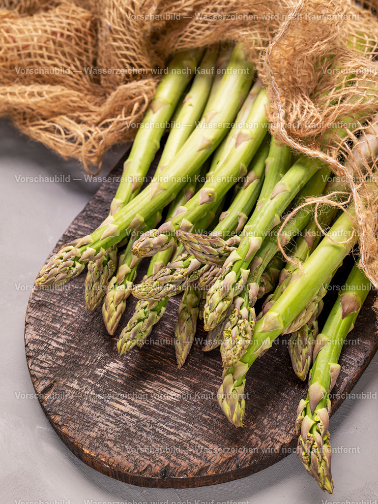 Nahaufnahme von fristen und rohen grünen Spargelstangen auf alten Holzbrett | Nahaufnahme von fristen und rohen grünen Spargelstangen auf alten Holzbrett, abgedeckt mit einen Sack - Realisiert mit Pictrs.com